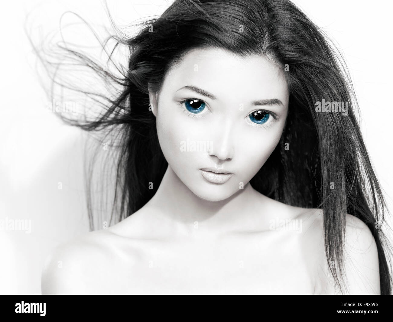 Bellezza ritratto di un simpatico giovane donna giapponese anime faccia con grandi occhi blu e capelli volanti. In bianco e nero con il colore blu. Foto Stock