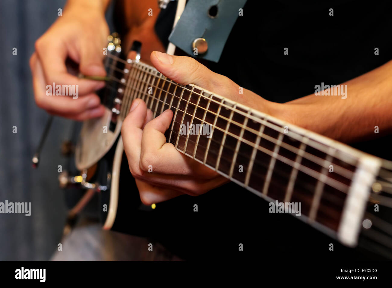 Immagine ravvicinata di un uomo con le sue dita sui tasti di un modo di suonare la chitarra Foto Stock
