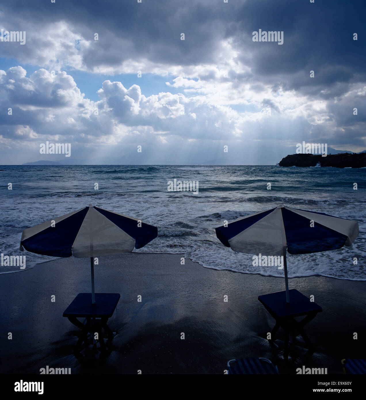 Due blu e bianchi ombrelloni su una spiaggia di sabbia Foto Stock