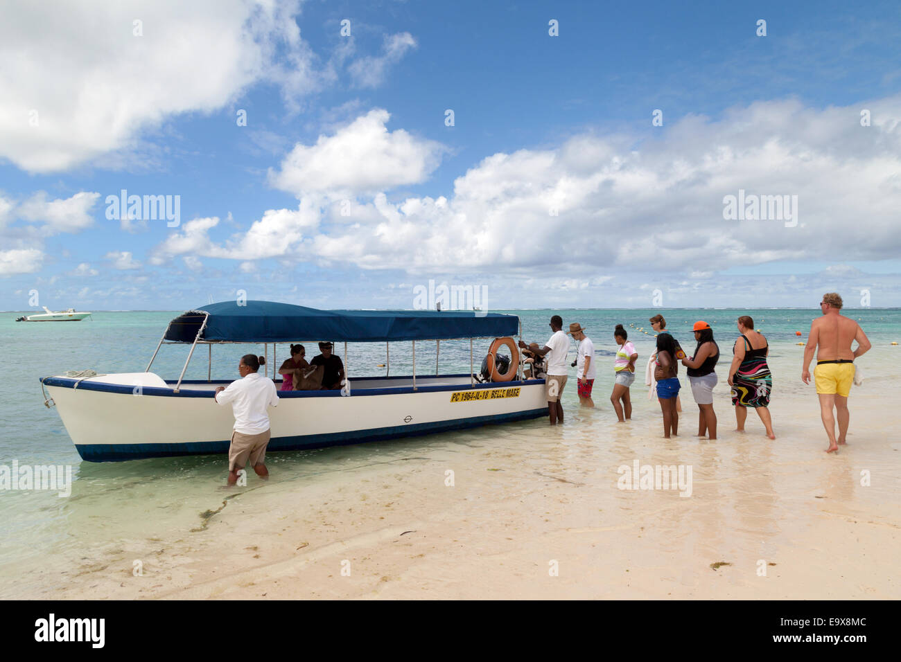 I turisti di salire a bordo di una barca dal fondo di vetro, Belle Mare spiaggia, Oceano Indiano, Mauritius Foto Stock