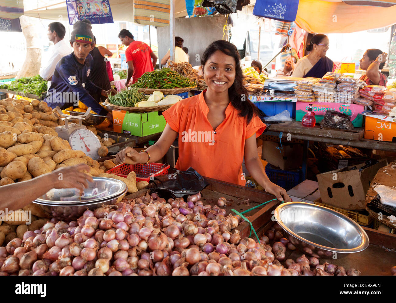 Mauritius Mahebourg; un sorridente Maurizio donna vendita alimentari presso il suo stallo, Mahebourg città mercato, Maurizio Foto Stock
