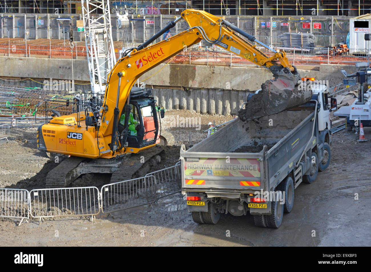 JCB scavatore scavatore caricamento di un camion ribaltabile con terra da costruzione seminterrato al progetto Elephant & Castle rigenerazione Londra Inghilterra UK Foto Stock