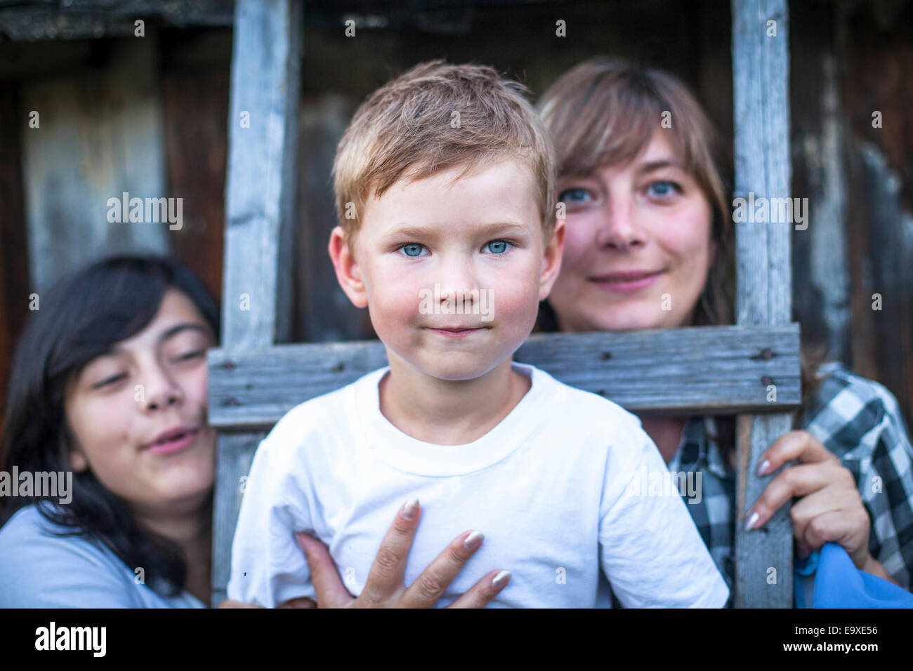 Ritratto di un bambino di cinque anni e con la madre e la sorella in background. Foto Stock