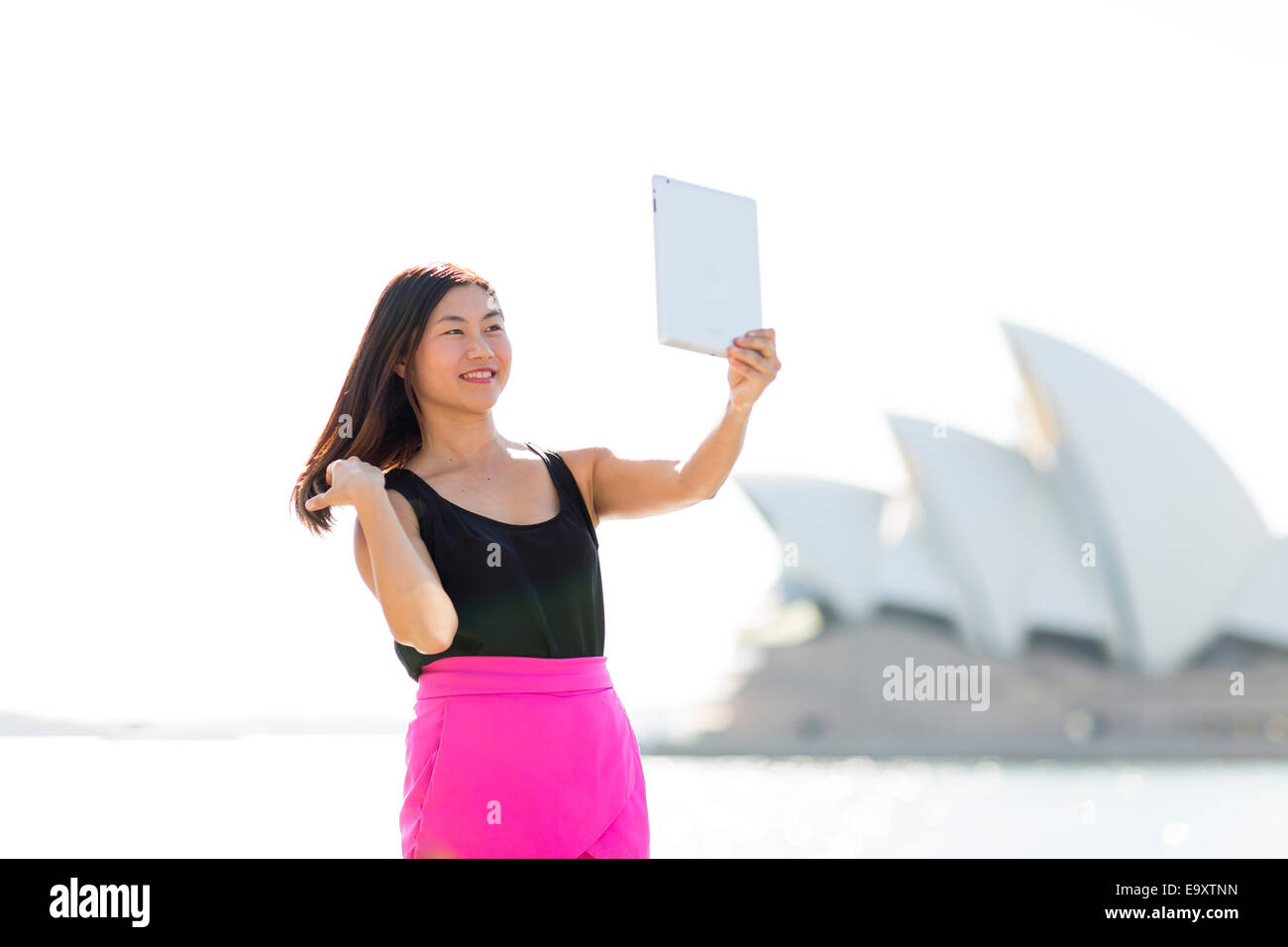 Una giovane donna prendendo un 'selfie' all'aperto Foto Stock