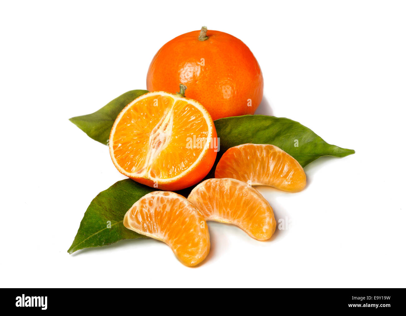 Intero e una metà Mandarine, pezzi singoli su foglie Foto Stock