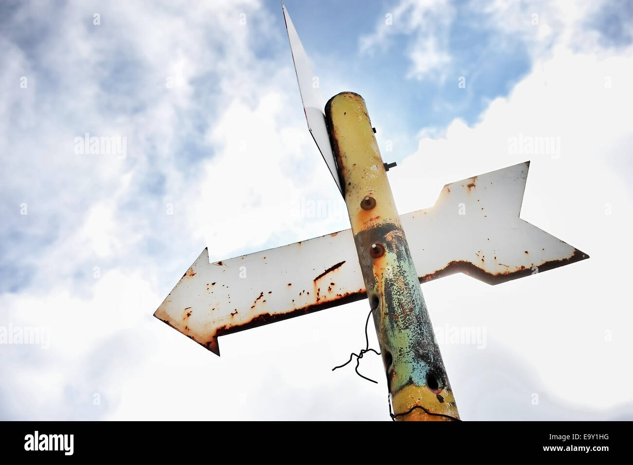 Rusty signpost freccia su un palo arrugginito Foto Stock
