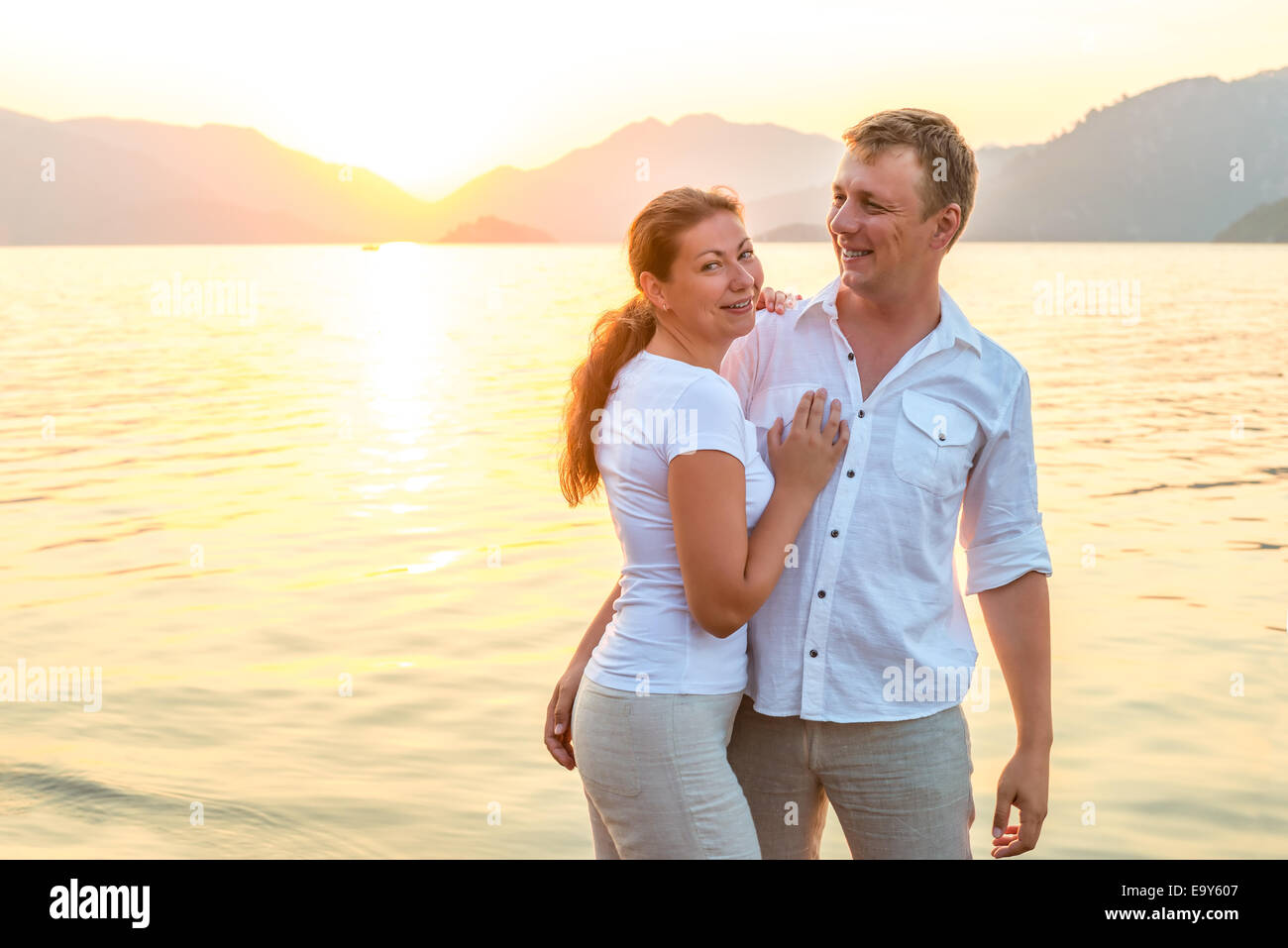 Happy sposi novelli abbracciando in riva al mare Foto Stock