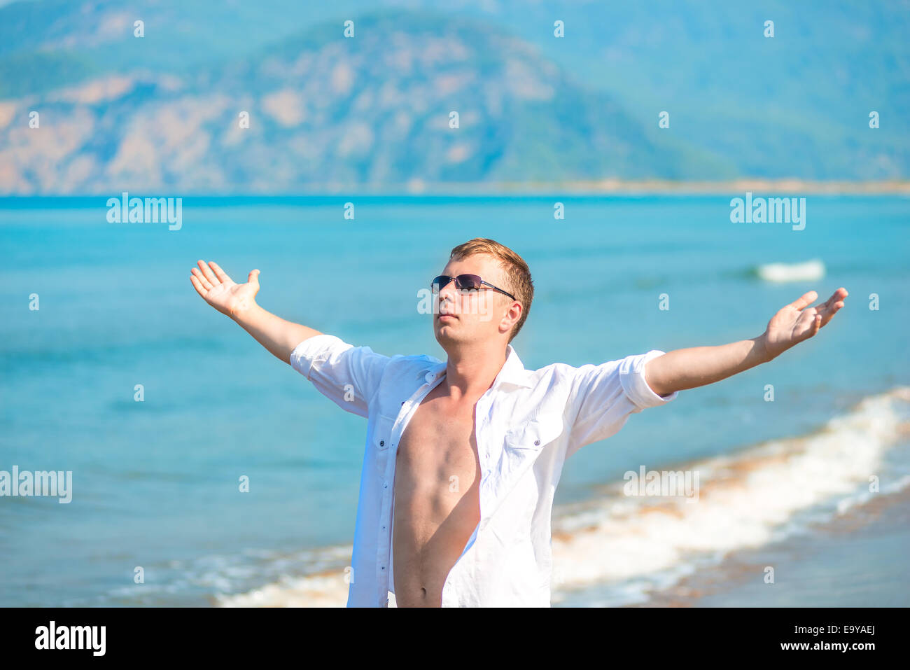Uomo di successo sullo sfondo del mare con le braccia aperte Foto Stock
