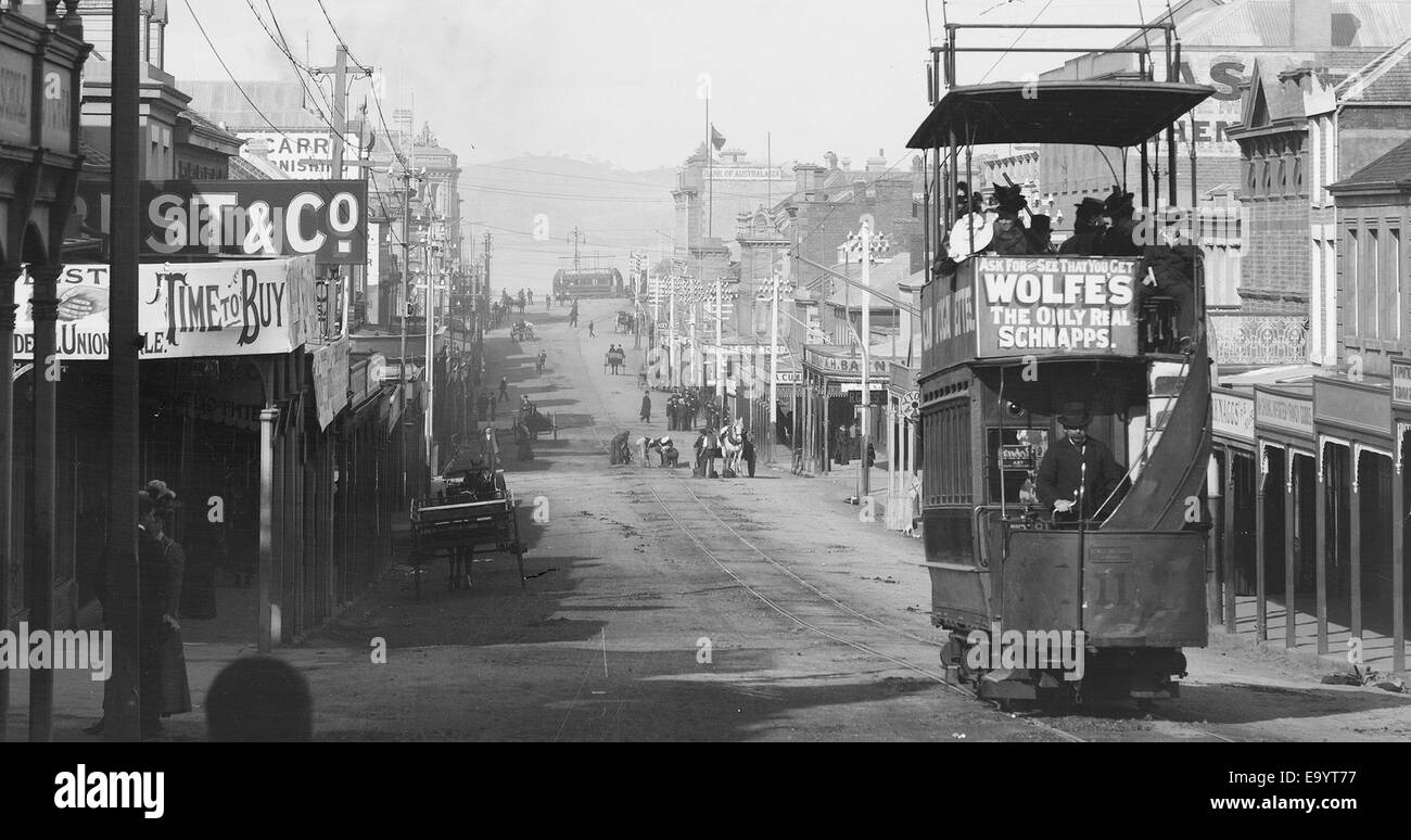 Elizabeth St guardando giù Melville San mostra il tram pubblicità Wolfe's Schnapps. Mostra filiale di banca d'Australasia & Gaylor il gioielliere (c1920) Elizabeth St guardando giù Melville St mostra il tram pubblicità Wolfe's 11229407633 o Foto Stock