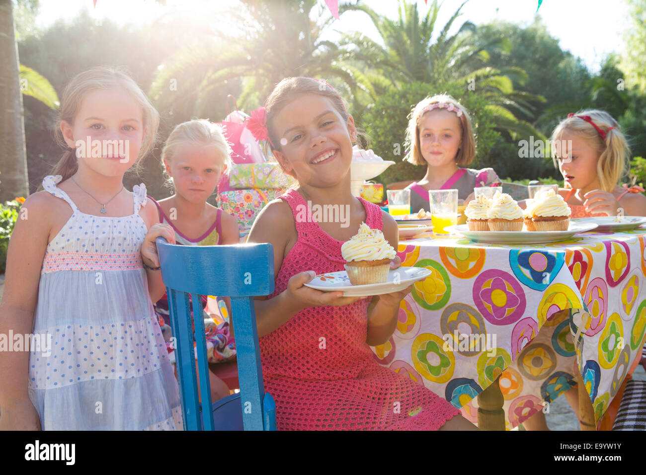 Ragazza alla festa di compleanno con gli amici tenendo la piastra con cupcake Foto Stock
