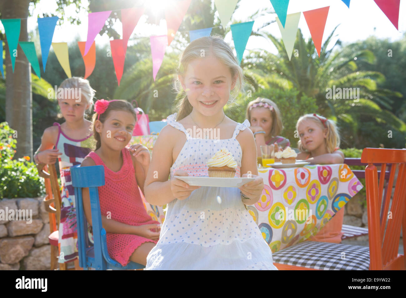 Ragazza alla festa di compleanno tenendo la piastra con cupcake Foto Stock