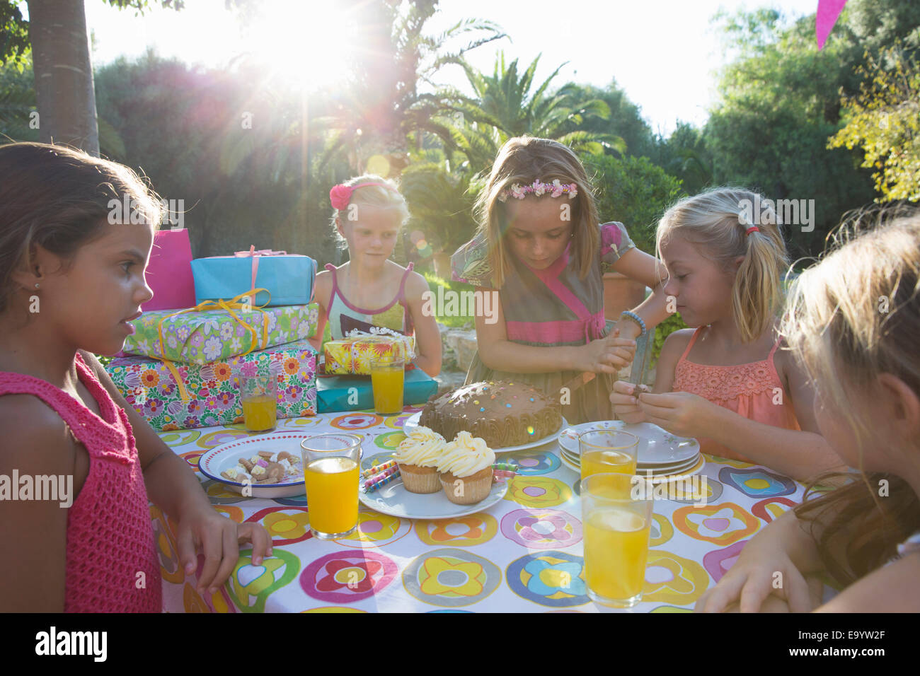 Le ragazze di taglio torta di compleanno con gli amici Foto Stock