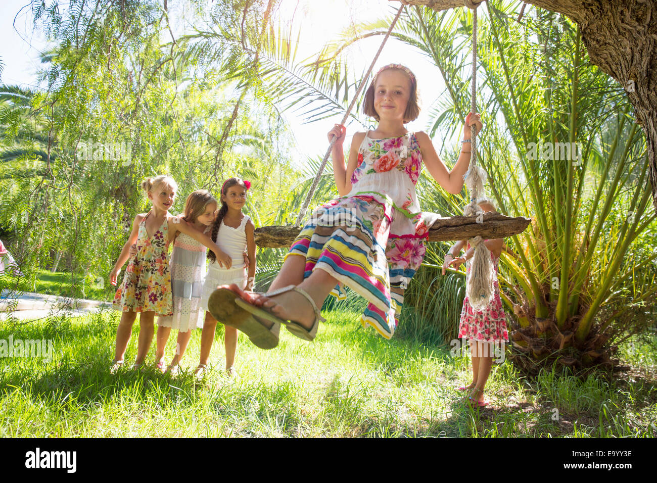 Ragazze queueing per albero oscillante nel giardino Foto Stock