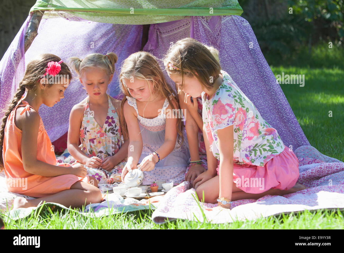Cinque ragazze di giocare con il giocattolo set da tè in giardino Foto Stock