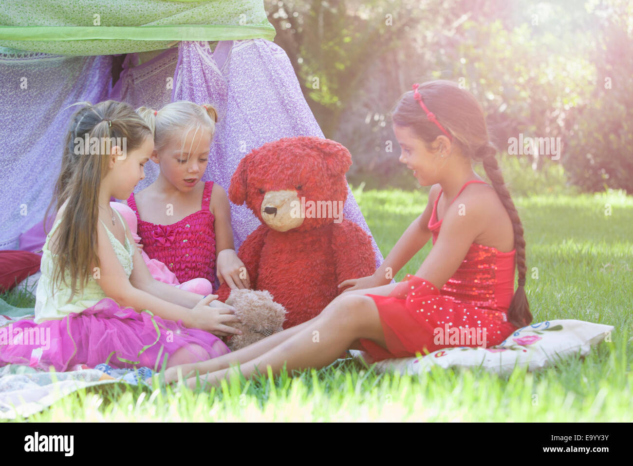 Le tre ragazze giocare con orsetti in giardino Foto Stock