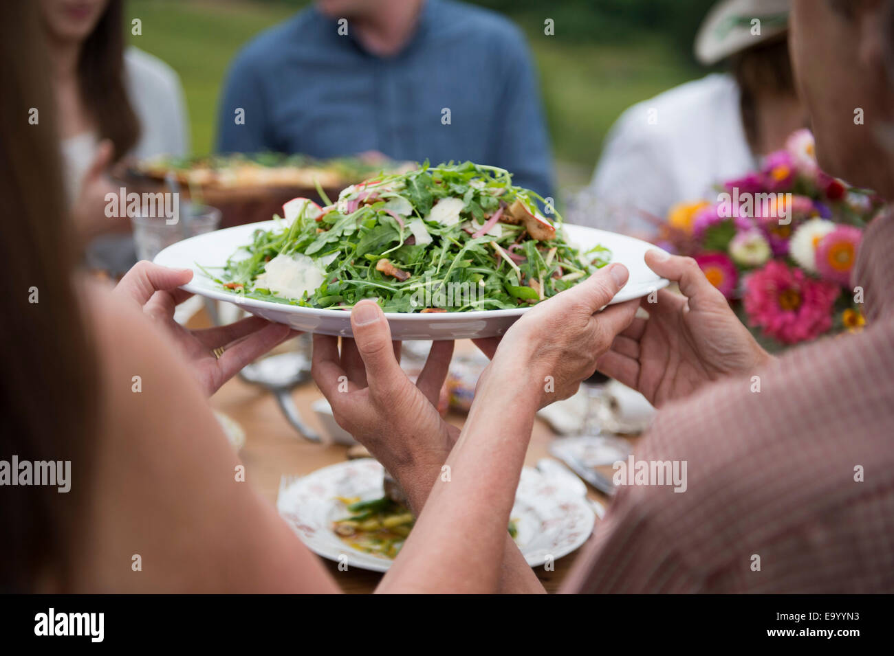 Gruppo di adulti gustando un pasto all'aperto Foto Stock