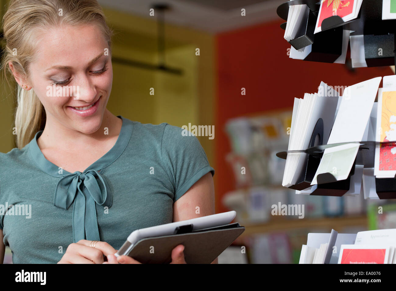 Femmina assistente di vendita utilizzando digitale compressa nella cartoleria Foto Stock