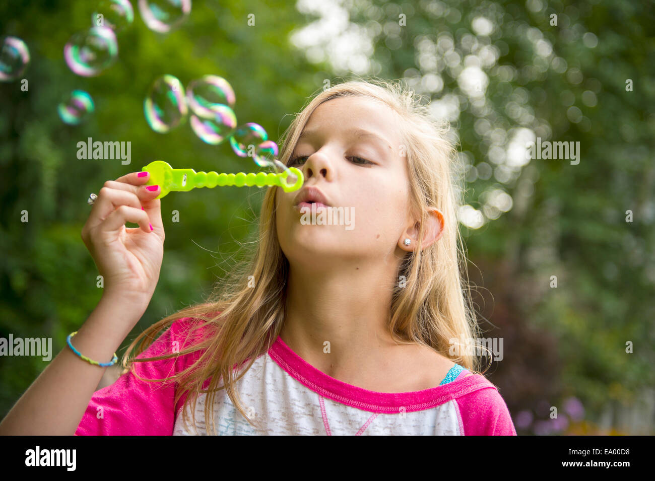 Ragazza a soffiare bolle in giardino Foto Stock