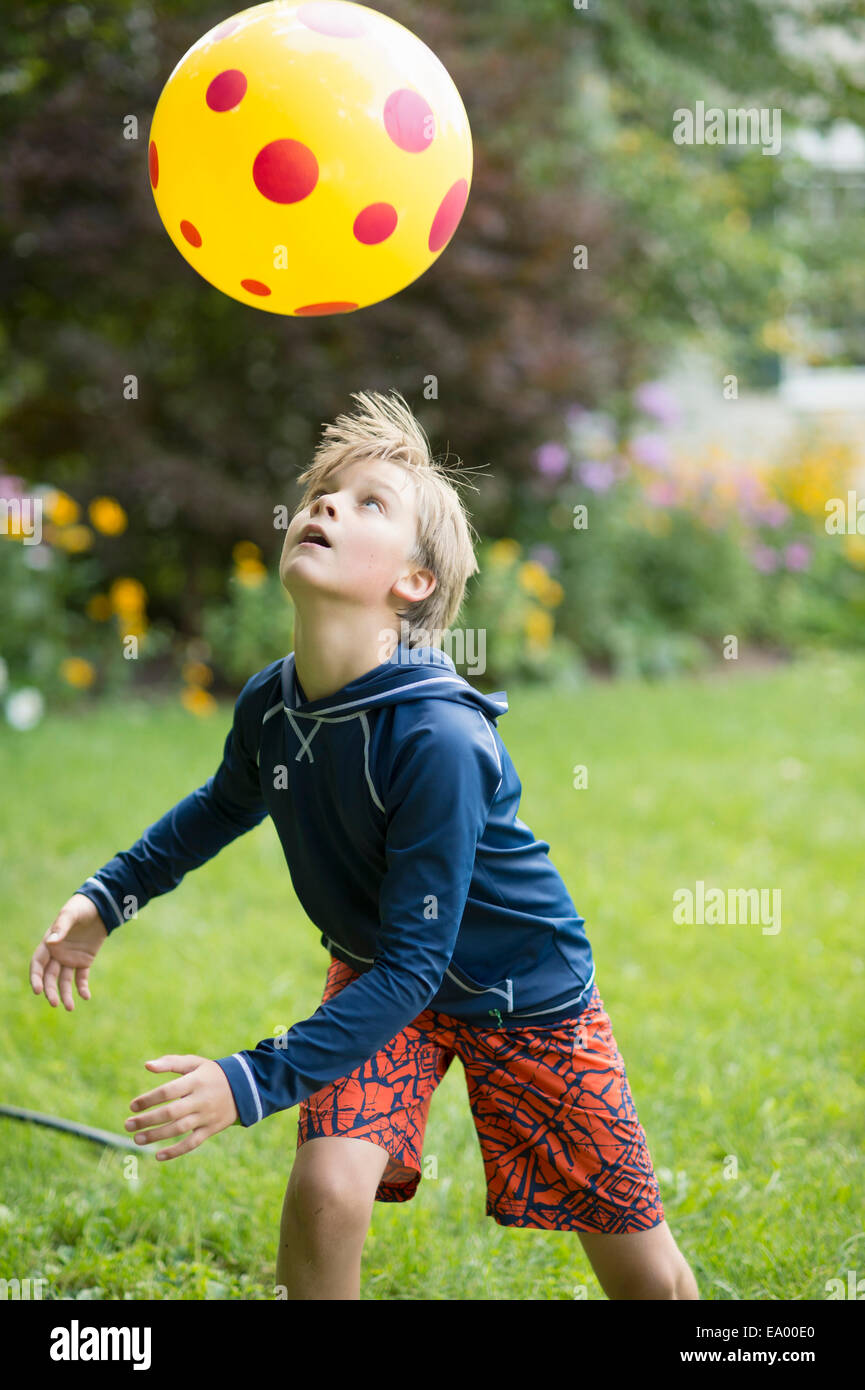 Ragazzo giocando con la palla di gioco in giardino Foto Stock