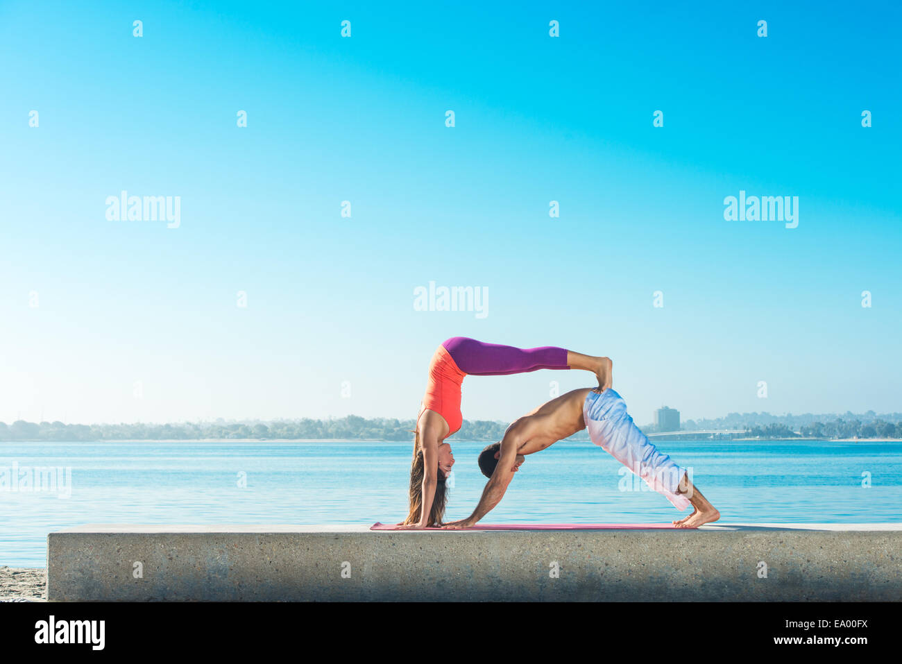 Giovane uomo e donna la pratica dello yoga sulla Pacific Beach, San Diego, California, Stati Uniti d'America Foto Stock