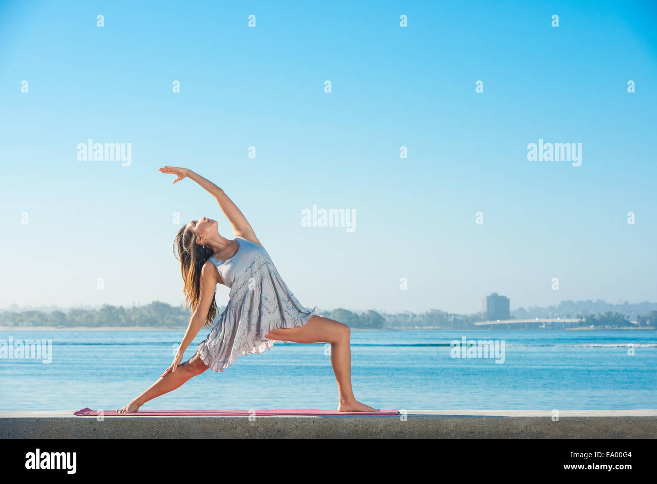 Giovane donna a praticare yoga sul molo a Pacific Beach, San Diego, California, Stati Uniti d'America Foto Stock