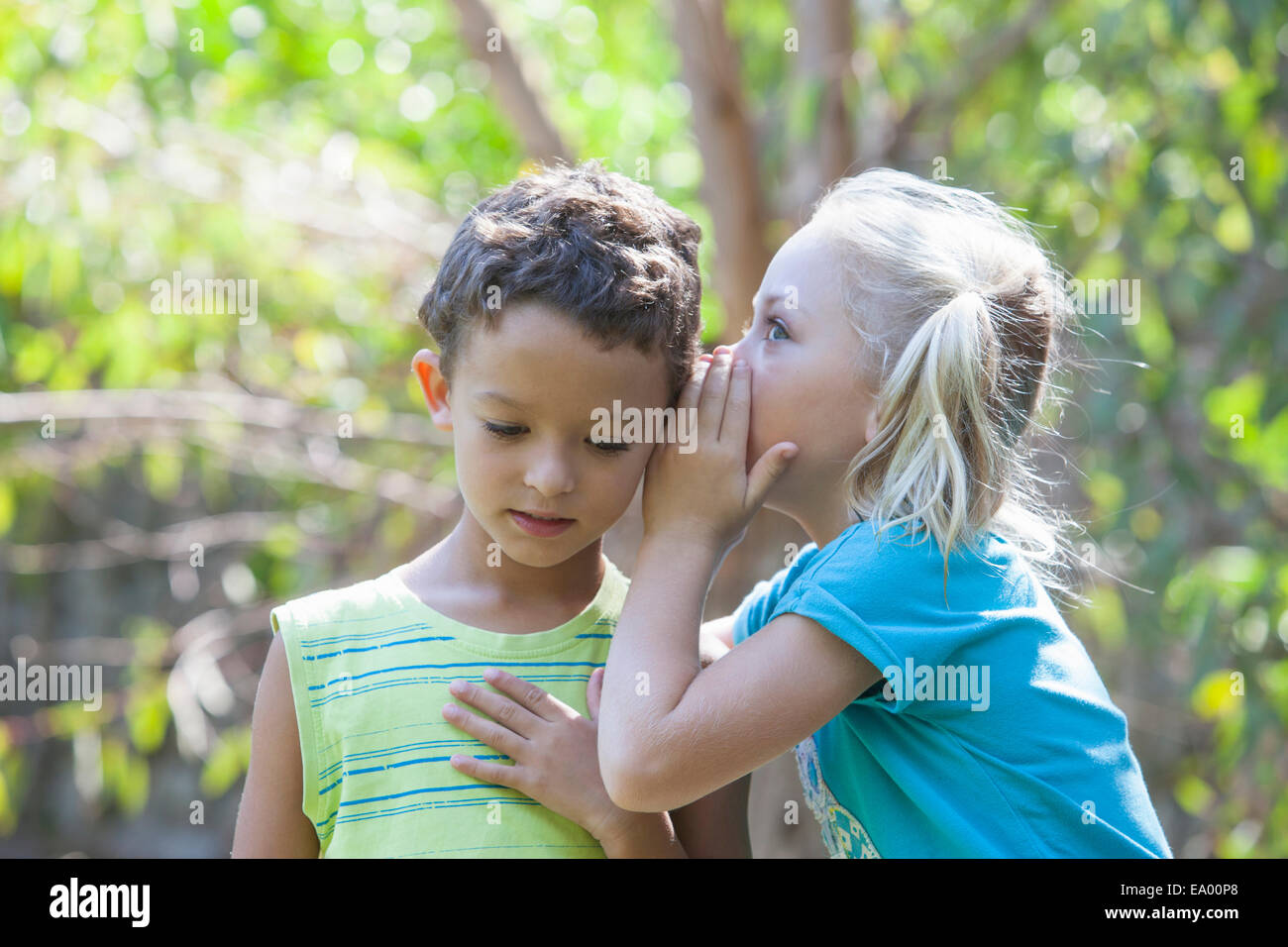 Ragazza whispering a boy in giardino Foto Stock