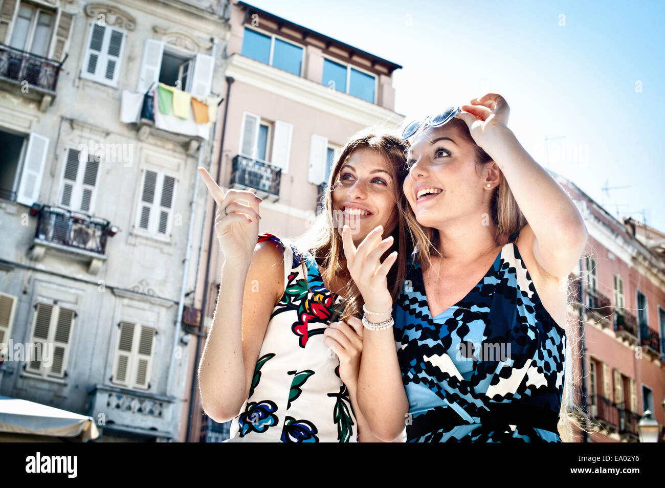 Due giovani amici di sesso femminile di puntamento e di ricerca sulla strada, Cagliari, Sardegna, Italia Foto Stock