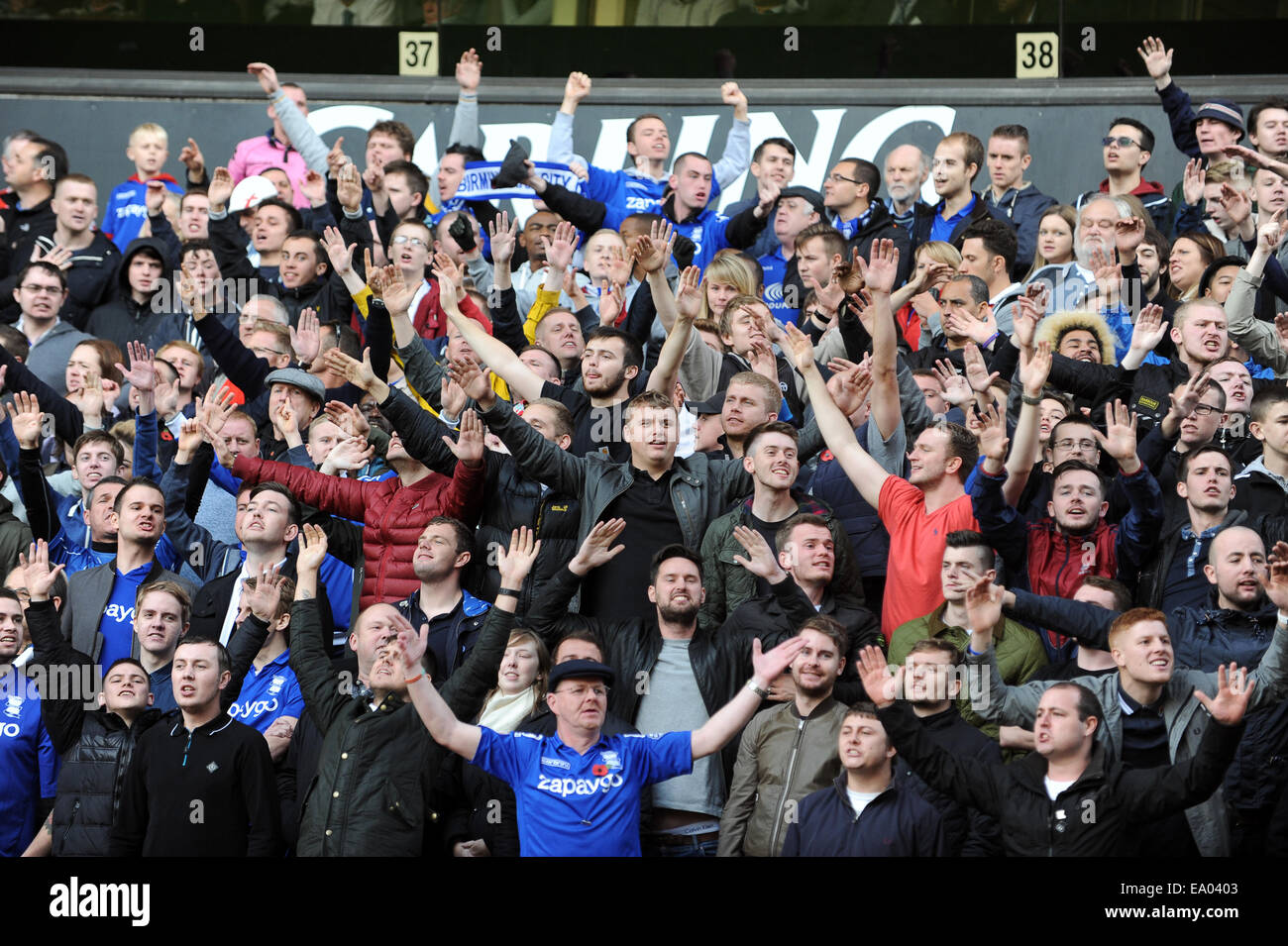 I tifosi di calcio tifosi affollano il salmodiare guardando la partita Birmingham City fans Uk Foto Stock