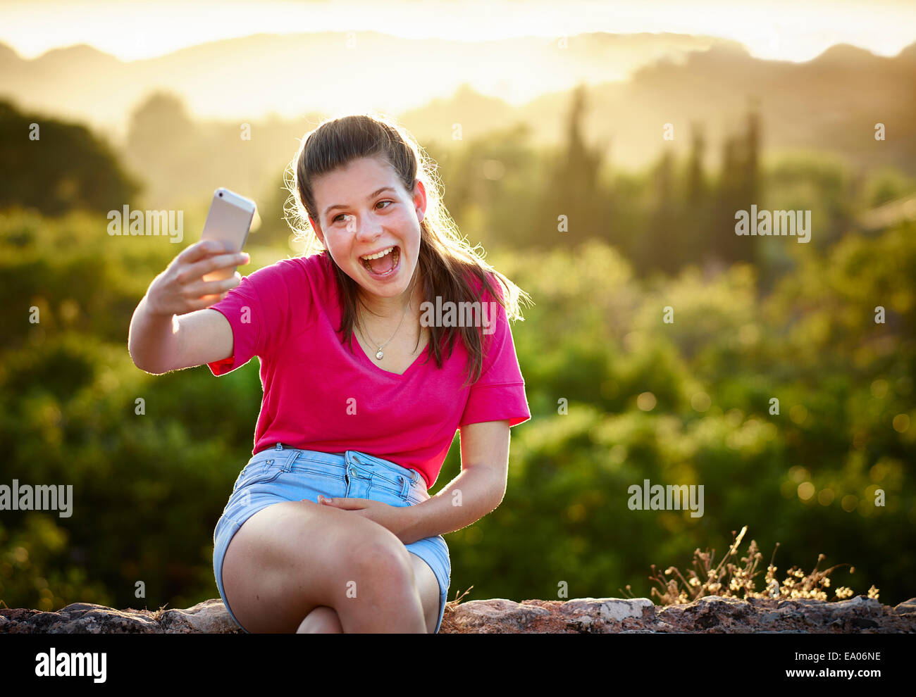 Ragazza adolescente rendendo volto per selfie sullo smartphone, Maiorca, SPAGNA Foto Stock