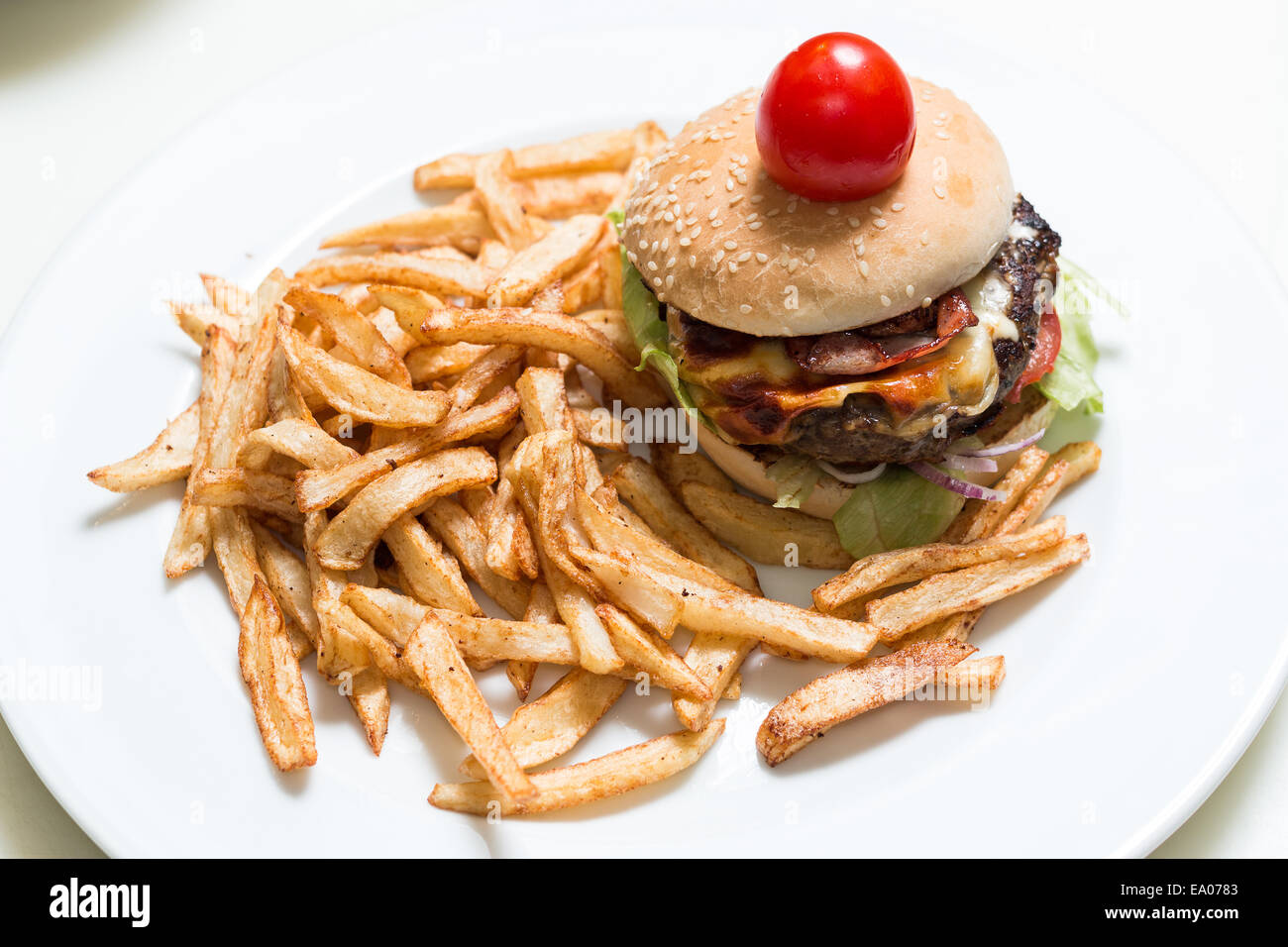 Hamburger e patatine fritte su una piastra bianca Foto Stock