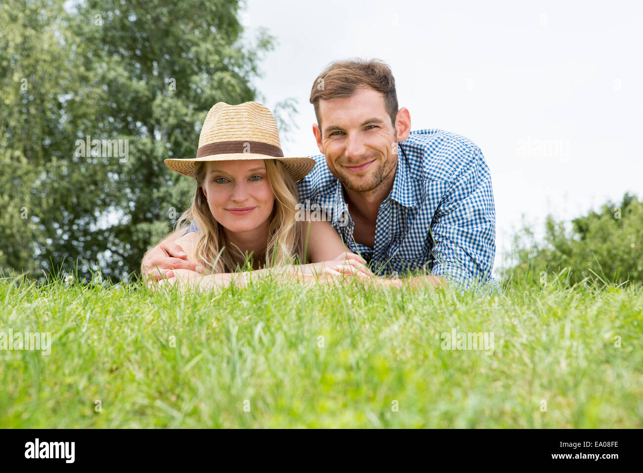 Metà adulto giovane giacente su erba, ritratto Foto Stock
