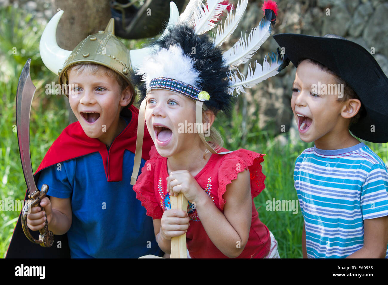Tre bambini indossare abiti fantasiosi costumi, giocando in posizione di parcheggio Foto Stock