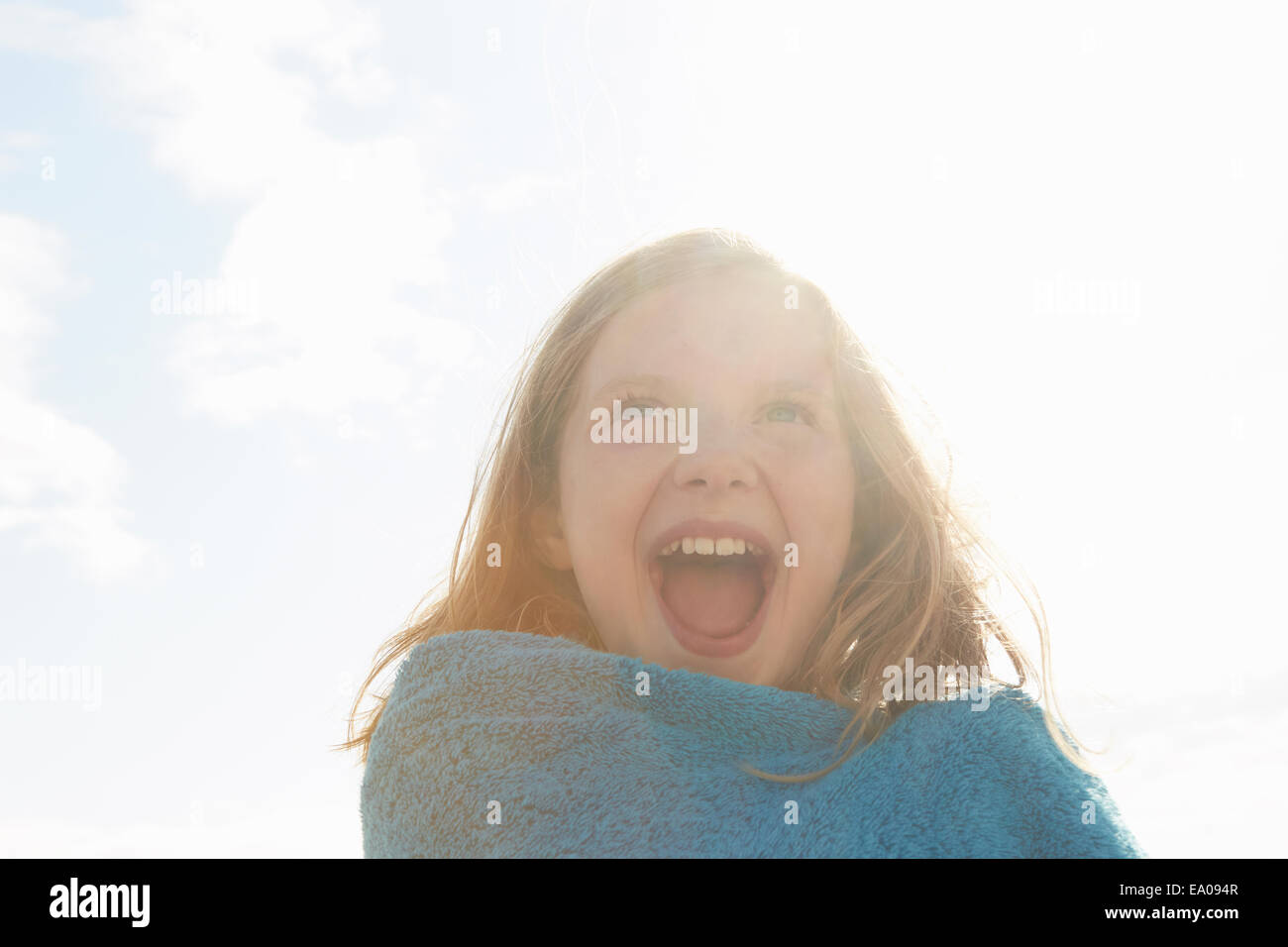Ritratto di ragazza ridere avvolto in asciugamano a costa soleggiata Foto Stock