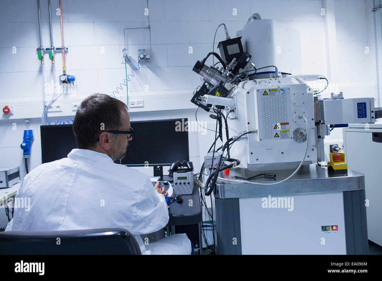Assistente di laboratorio lavora con microscopio elettronico a scansione Foto Stock Assistente di laboratorio lavora con microscopio elettronico a scansione Foto Stock