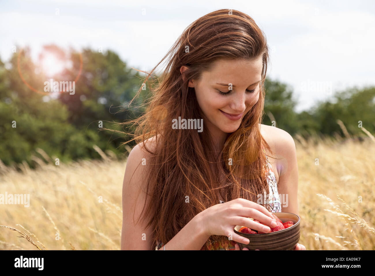 Giovane donna vaschetta di contenimento di frutta fresca nel campo Foto Stock