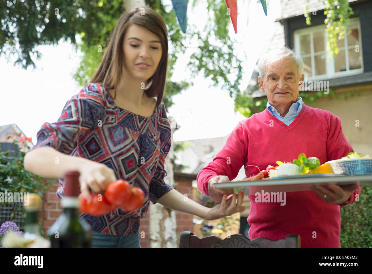 Nonno che porta il vassoio con il nipote nella tabella di impostazione Foto Stock