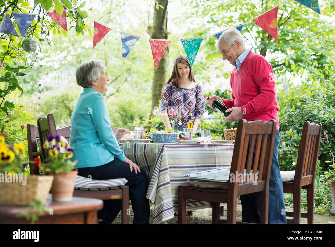 Famiglia di sedersi per un pasto all'aperto Foto Stock