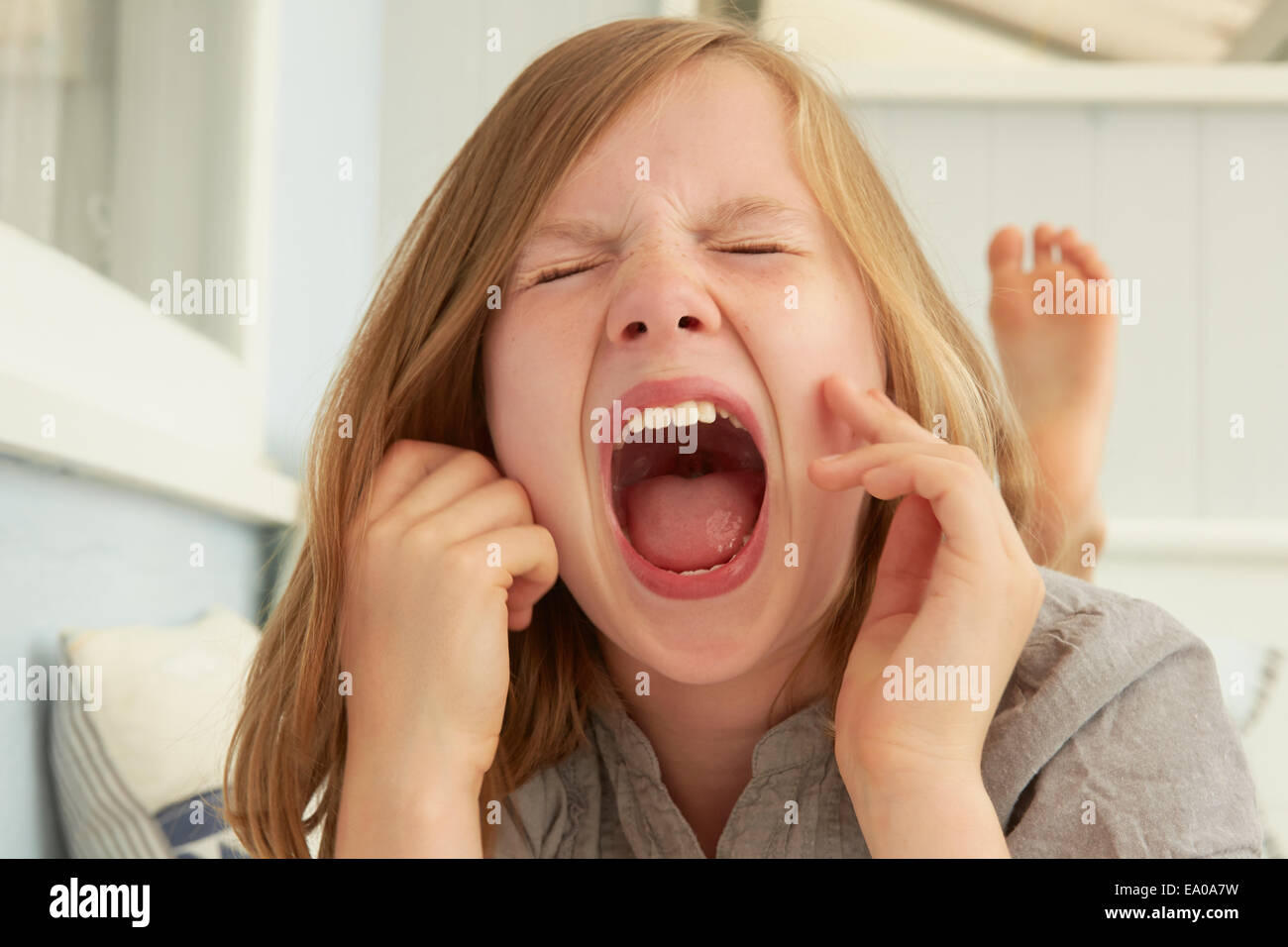 La ragazza con gli occhi chiusi urlando in Appartamento vacanze Foto Stock