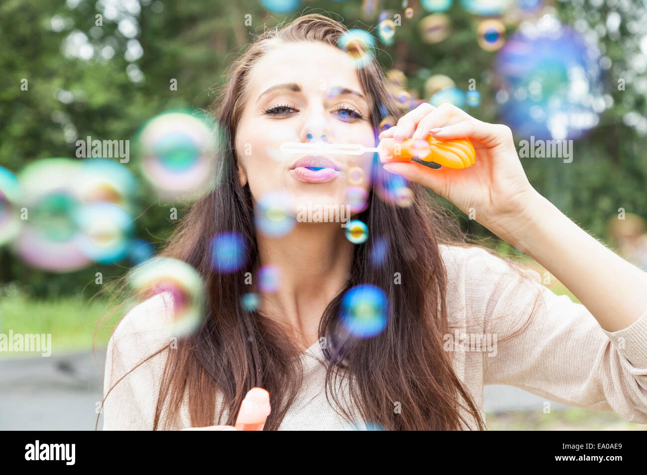 Giovane donna a soffiare bolle Foto Stock