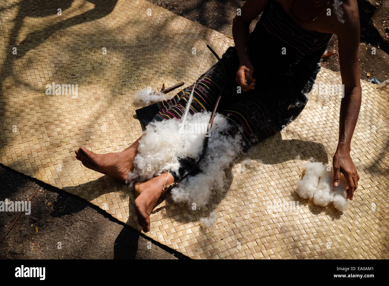 Una donna sta preparando il cotone per essere utilizzato nel processo di tessitura a Lamagute, Lembata, Nusa Tenggara orientale, Indonesia. Foto Stock