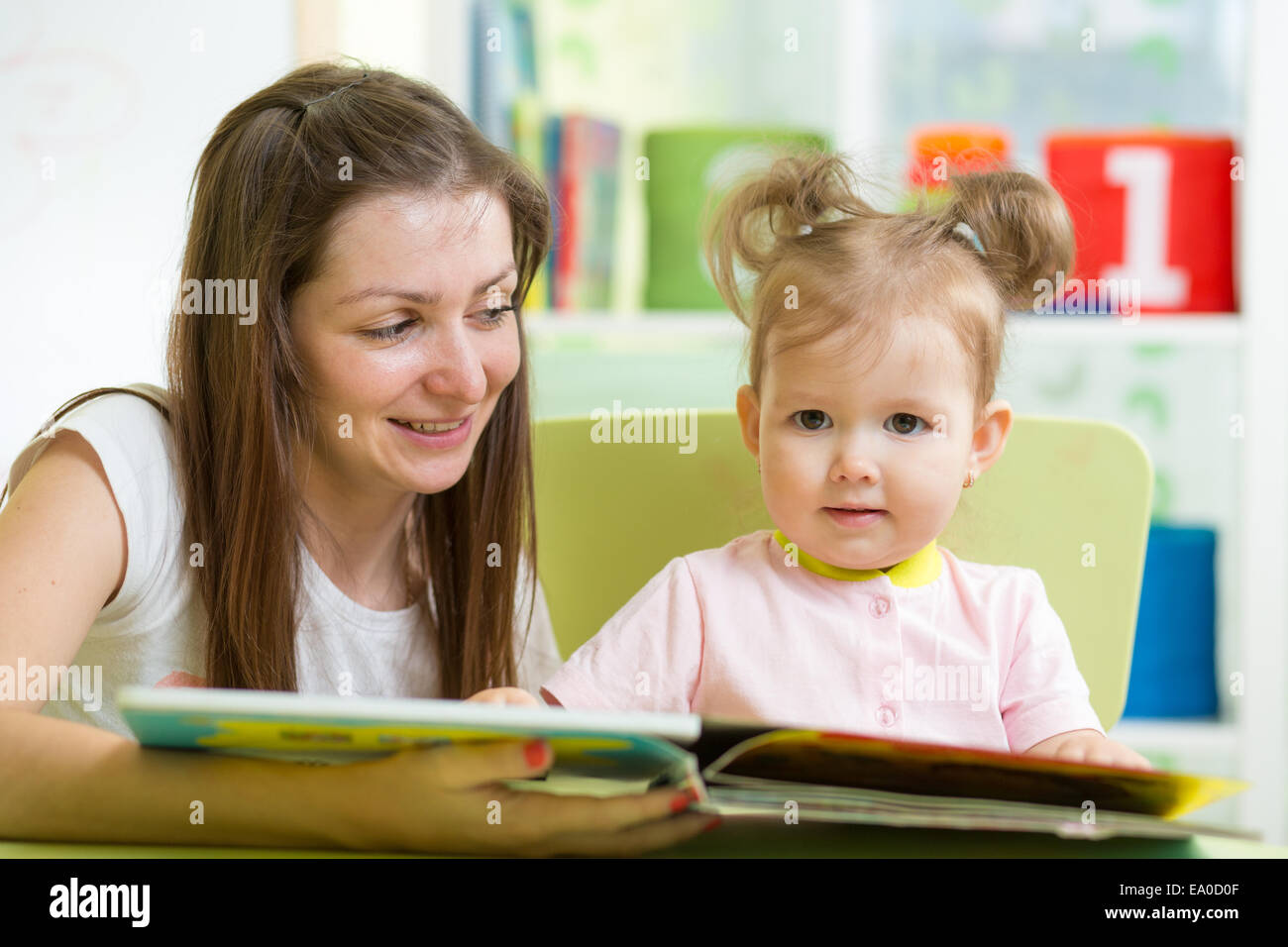 Ragazzo e una ragazza madre di leggere un libro in ambienti interni Foto Stock