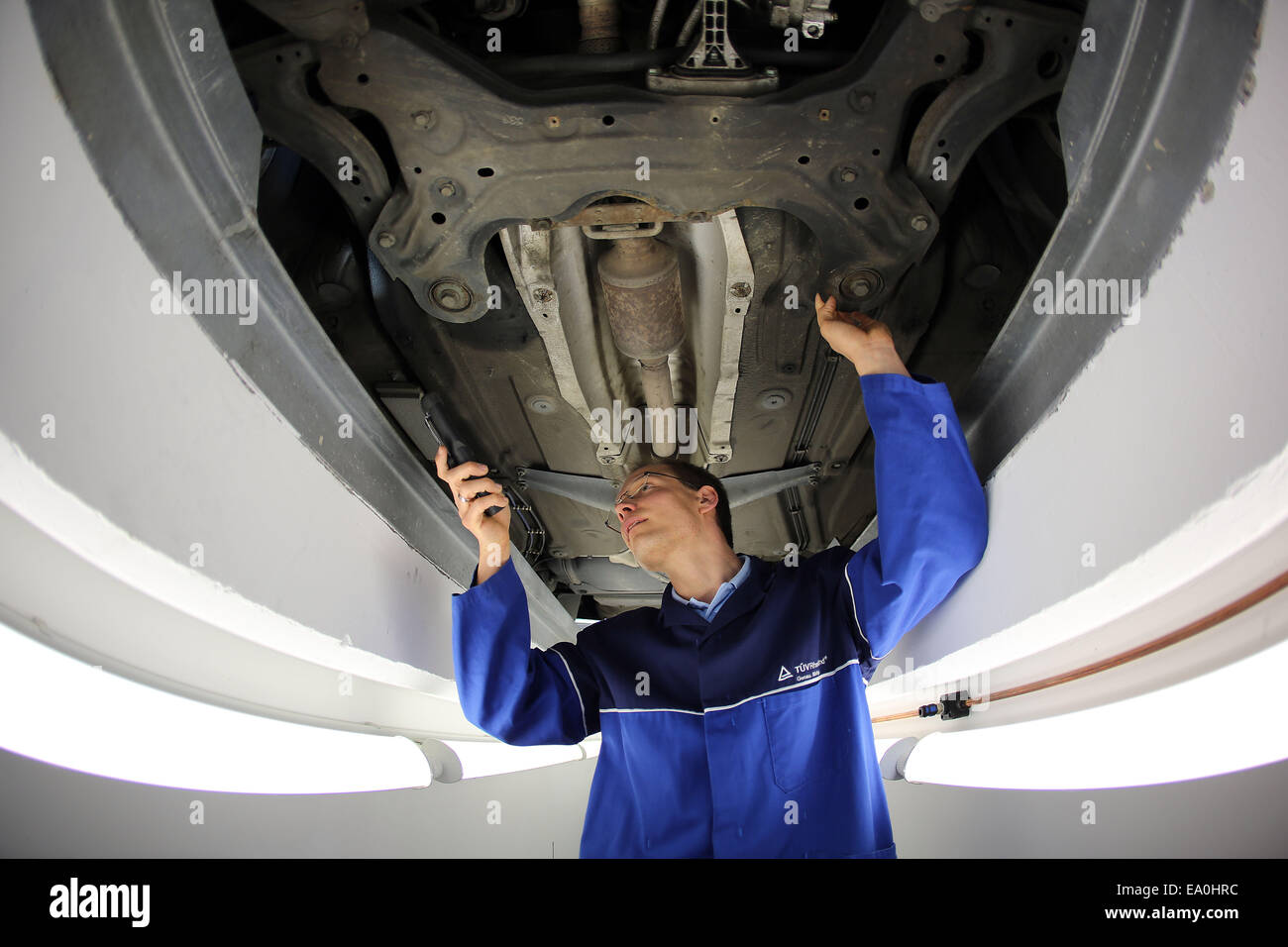 Colonia, Germania. 03 Nov, 2014. Un TUEV (tedesco Technical Inspection Agency, eseguendo MOTs sui veicoli) esaminatore esamina un auto durante un MOT a Colonia, Germania, 03 novembre 2014. Il TÜV presenterà la sua relazione 2015 il 05 novembre 2014. La relazione rivela il livello di sicurezza tecnica dei veicoli a motore su strade tedesco. Foto: Oliver Berg/dpa/Alamy Live News Foto Stock