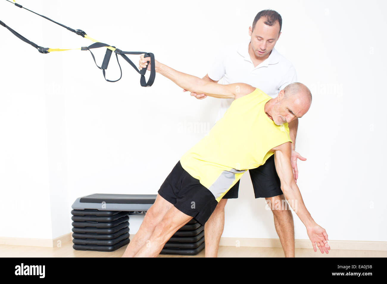 Uomo anziano rendendo la formazione di sospensione con pullman Foto Stock