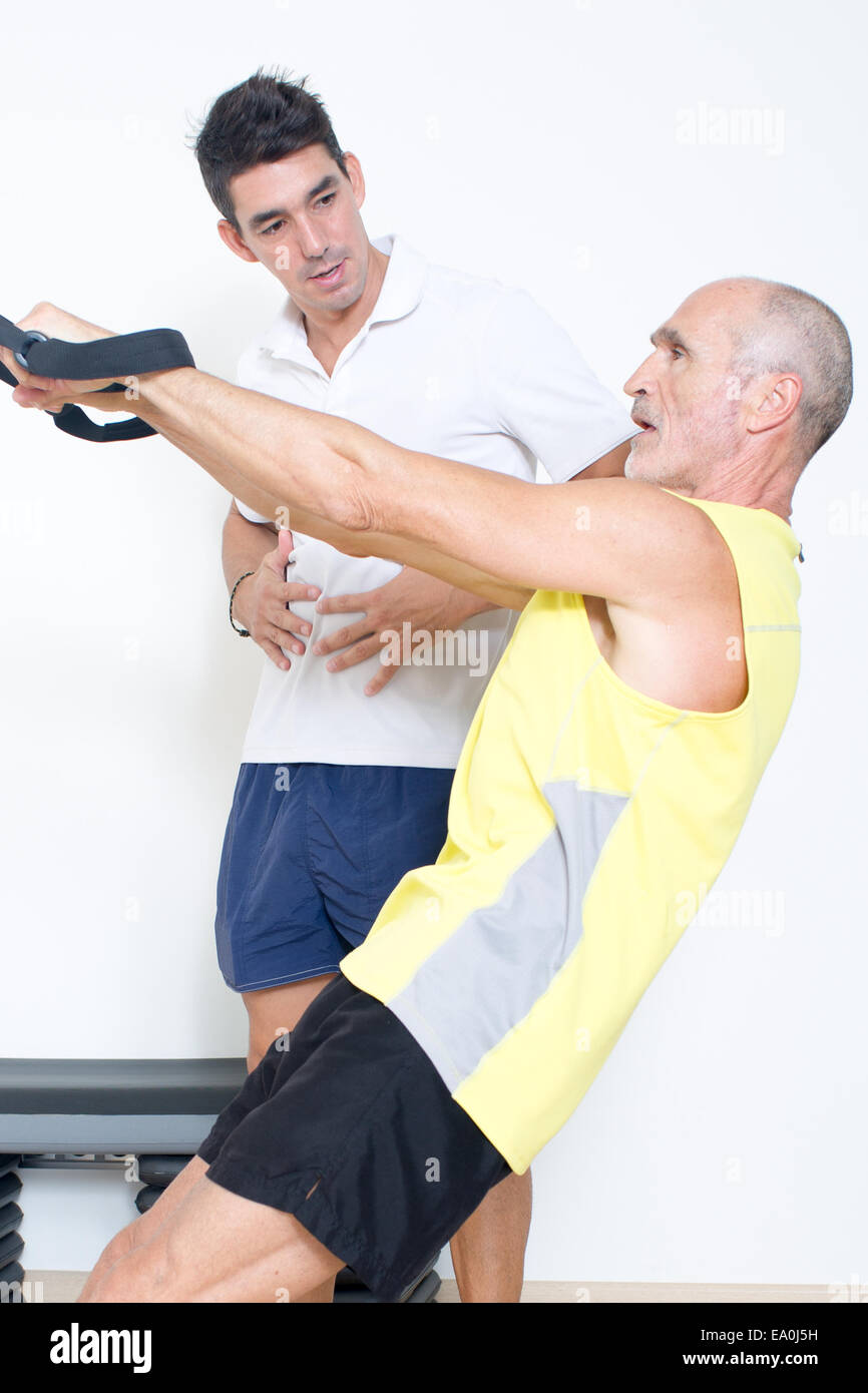 Uomo anziano rendendo la formazione di sospensione con pullman Foto Stock