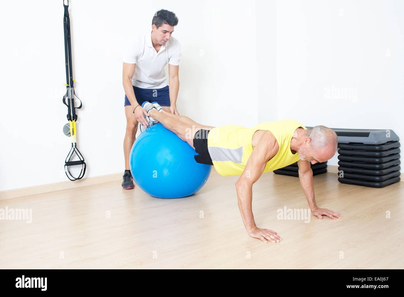 Uomo anziano rendendo la formazione di sospensione con pullman Foto Stock