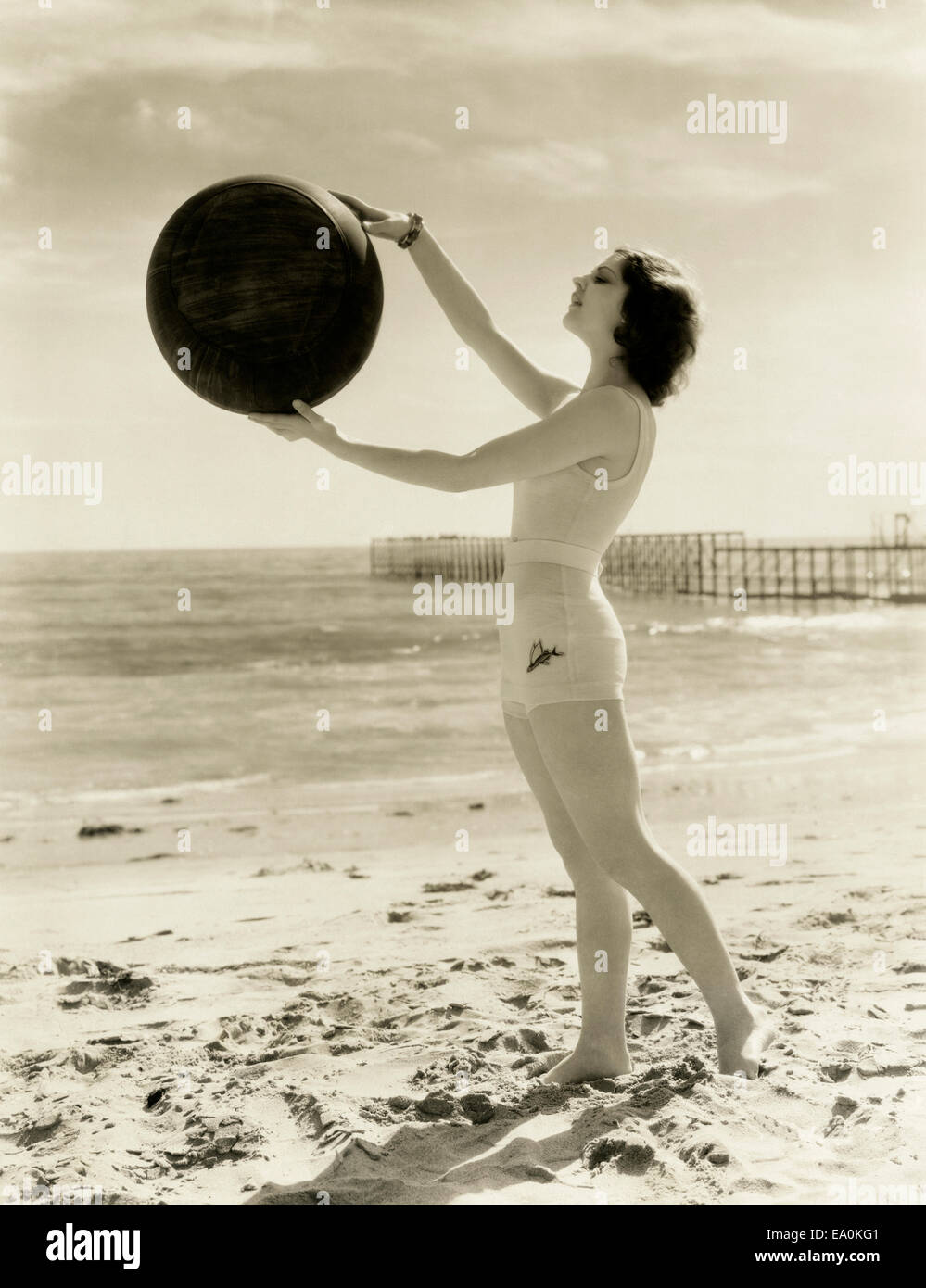 Il bilanciamento di una palla medica sulla spiaggia Foto Stock