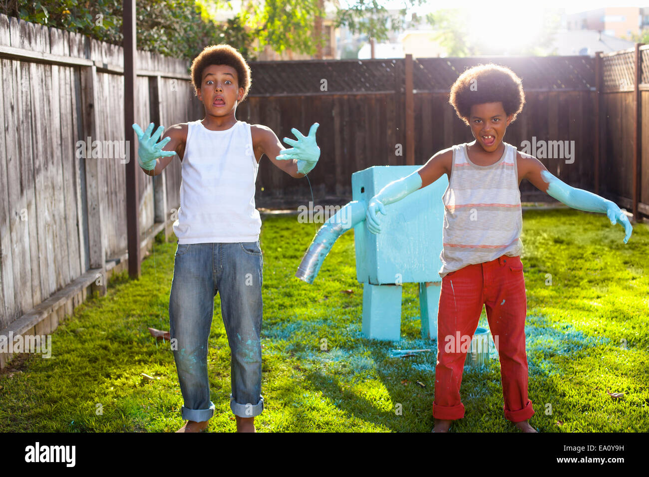 Ritratto di due fratelli in giardino con la luce blu vernice sulle mani e braccia Foto Stock