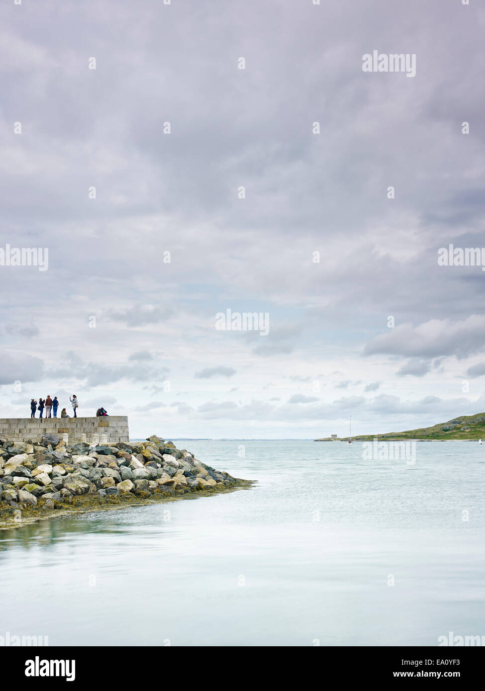 Un gruppo di persone in piedi sulla parete del porto, Howth, la baia di Dublino, Repubblica di Irlanda Foto Stock