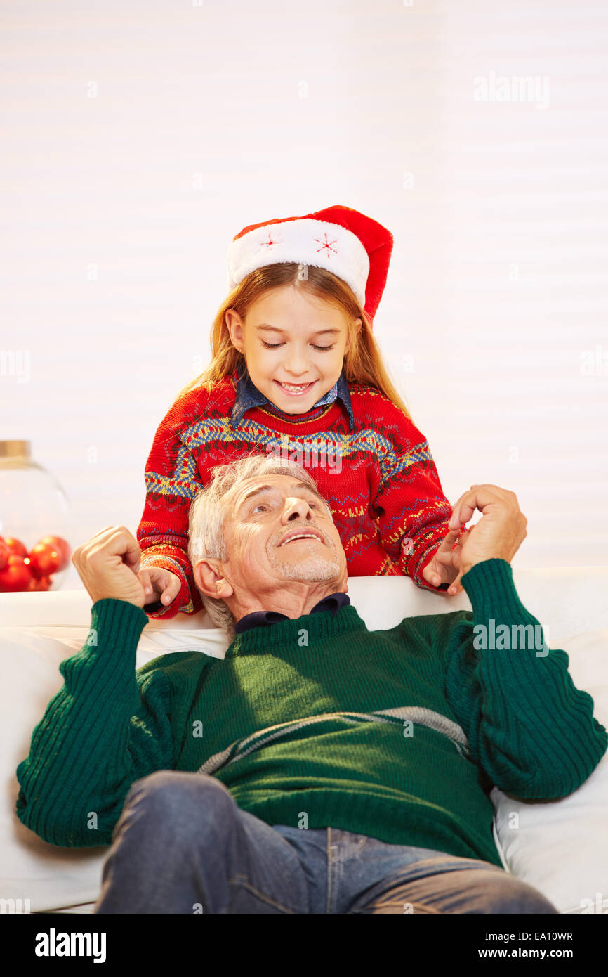 Felice ragazza sorridente e nonno giocando insieme a natale Foto Stock