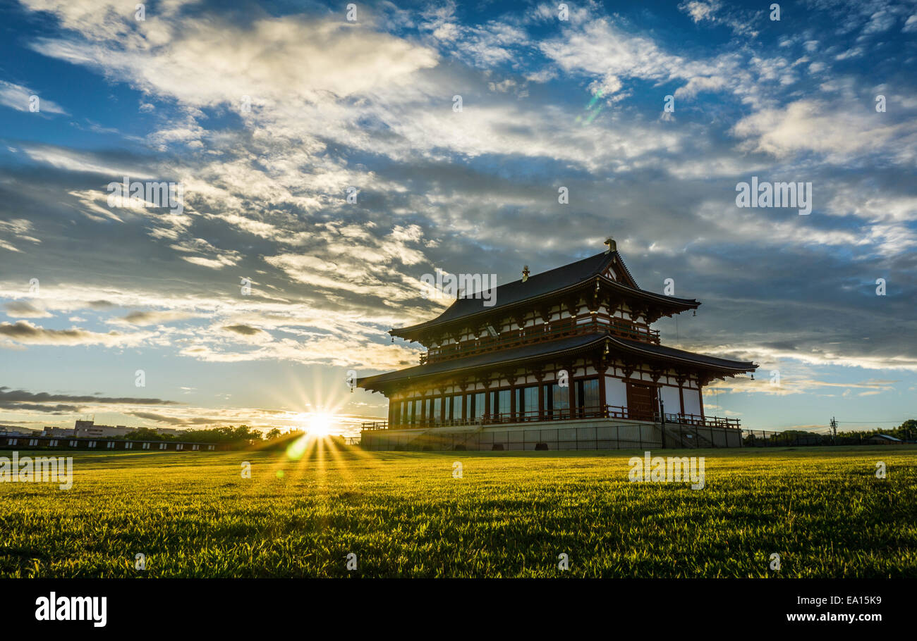 Grande palazzo reale giapponese tradizionale in un campo verde al tramonto. Sala del pubblico Daigokuden presso il sito del Palazzo Heijo, a Nara, Giappone Foto Stock